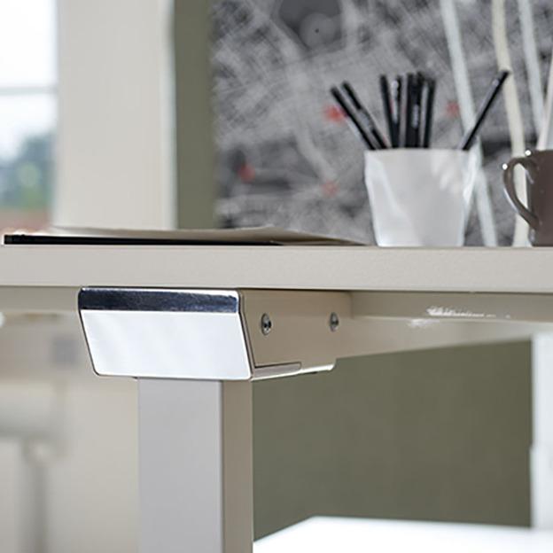 Weißer höhenverstellbarer Schreibtisch mit Tasse, Stiftebecher und Bildschirm.