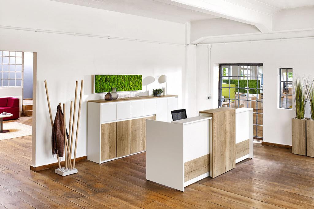 Empfangsbereich im Büro Heller Empfangsbereich mit einer Kombination aus weißen und holzfarbenen Möbeln, grüner Wanddekoration und Holzboden.