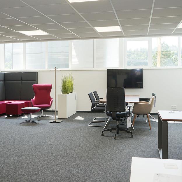 Bunte Büromöbel und weißer Konferenztisch mit sechs Stühlen