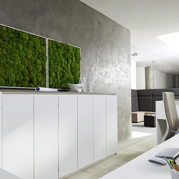 Impression eines Empfangsbereichs mit weißen Aktenschränken und einem Bürostuhl an einem Schreibtisch