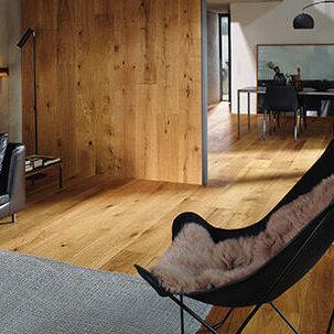 Wandverkleidung passend zu Bodenfarbe aus Holz mit Sessel im Vordergrund