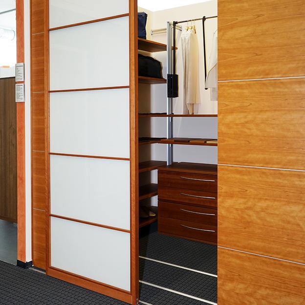 Einbauschrank mit einer geöffneten weißen Gleittür