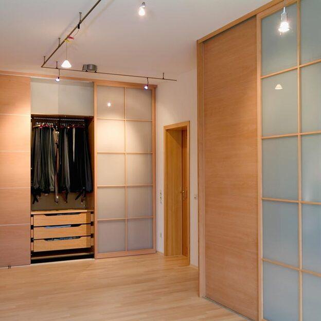 Impression eines Raumes mit einem Gleittürschrank aus Holz