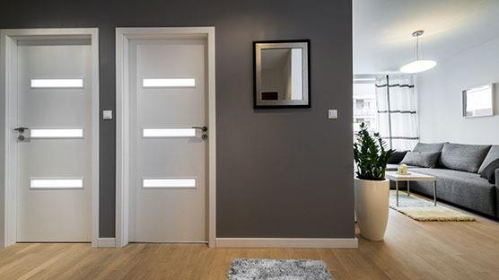 Zwei weiße Innentüren mit Beleuchtung in grauer Wand