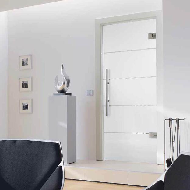 Hochwertige Tür nach Maß mit Glaselementen und Edelstahlgriff in stilvollem Innenraum.