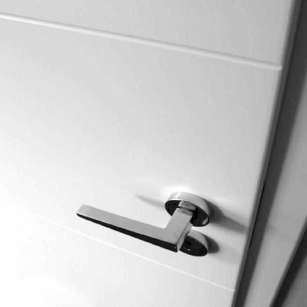 Nahaufnahme einer Tür nach Maß mit stilvollem, kantigem Türgriff in Edelstahloptik