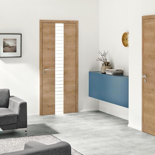 Zwei moderne Holztüren nach Maß in einem stilvollen Wohnraum. Eine Tür verfügt über einen schmalen vertikalen Glaseinsatz mit horizontalen Streifen, während die andere mit einer natürlichen Holzmaserung eine warme Atmos