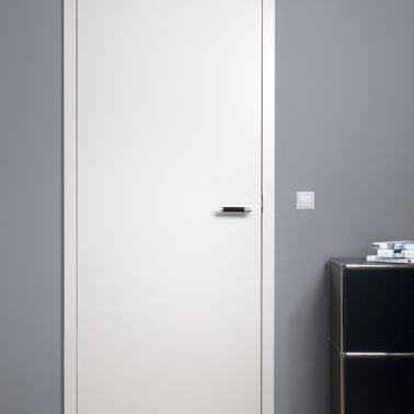 Minimalistische Tür nach Maß in schlichtem Weiß mit modernem Türgriff in Chromoptik. Die Tür fügt sich harmonisch in den modernen Raum mit dunkler Wandfarbe, Parkettboden und stilvollem schwarzen Sideboard ein.