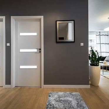 Zwei weiße Innentüren mit Beleuchtung in grauer Wand