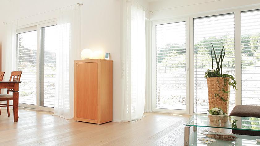 Schmaler Schrank aus Holz im Esszimmer vor weißer Wand
