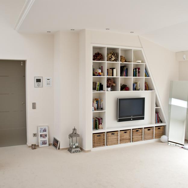 Weißer Einbauschrank um Fernseher mit leichter Schräge