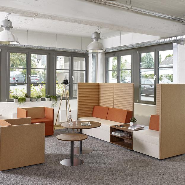 Lounge in gemütlichen Brauntönen Drei Loungeelemente in Brauntönen um zwei runde Tische