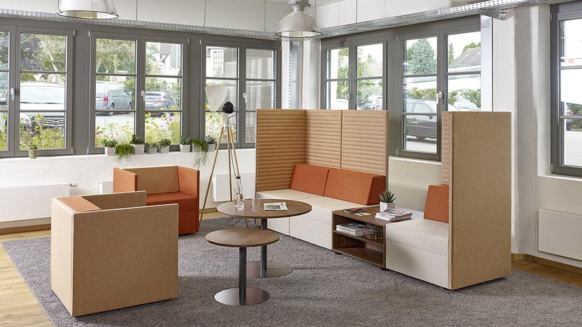 Lounge in gemütlichen Brauntönen Drei Loungeelemente in Brauntönen um zwei runde Tische