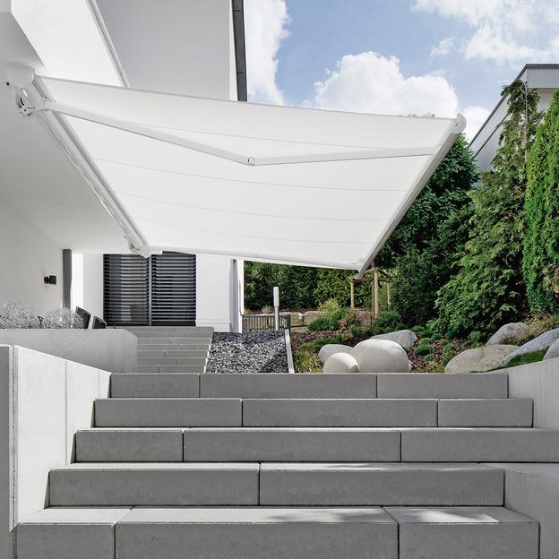 Weiße Gelenkarmmarkise als stilvoller Sonnenschutz über modernem Terrassenbereich mit Treppe