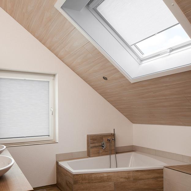 Wabenplissees als effektiver Sonnenschutz an Dachfenster und Badfenster in modernem Badezimmer