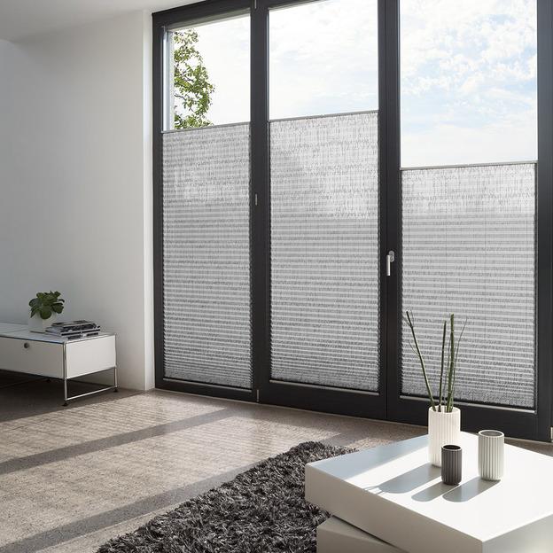 Halbtransparente Plissees als Sicht- und Sonnenschutz an bodentiefen Fenstern im Wohnraum