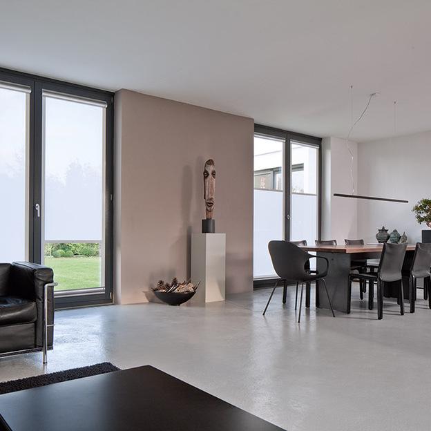 Weiße Rollos als schlichter, lichtdurchlässiger Sonnenschutz in modernem Ess- und Wohnbereich