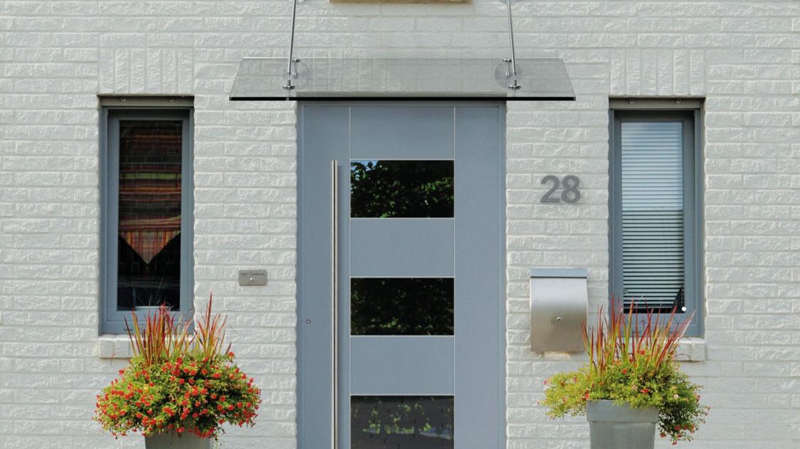 Kleines Vordach aus Glas über blauer Haustür