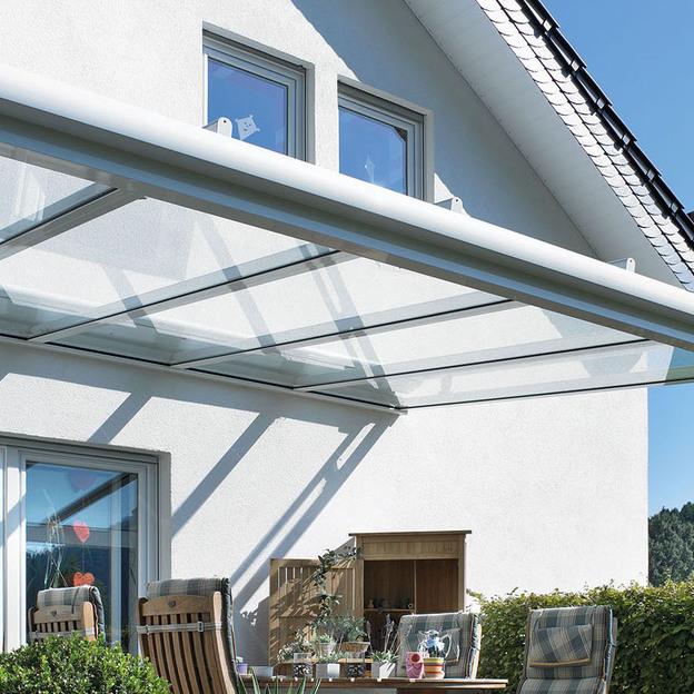 Modernes Haus mit elegantem Vordach Ein zeitgemäßes Haus mit einem schlanken Vordach aus Glas und Stahl, das dem Eingangsbereich Schutz bietet und einen ansprechenden architektonischen Akzent setzt.