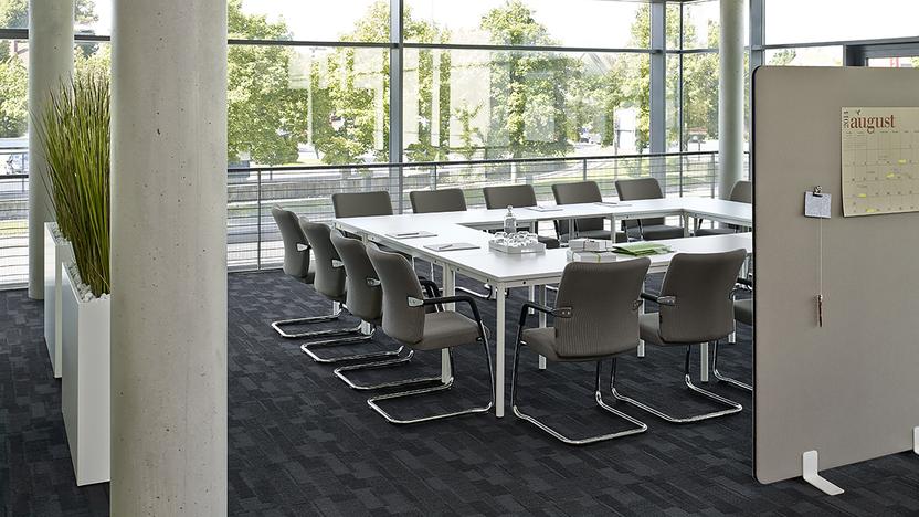 Weißer Konferenztisch im Büro vor Trennwänden