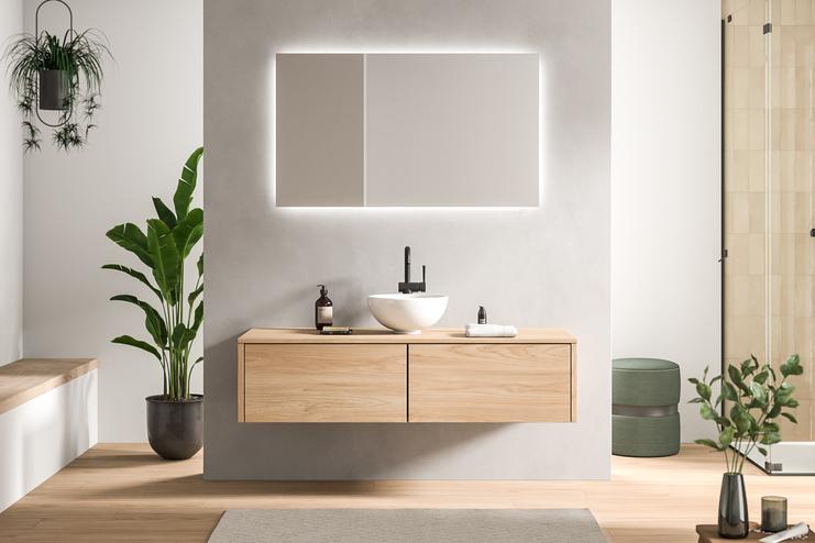 Maßgefertigtes Bad mit hellem Holz und moderner Beleuchtung Geschmackvoll gestaltetes Bad nach Maß mit einem hellen Holzwaschtisch und einem rechteckigen, beleuchteten Spiegel, umgeben von Pflanzen.